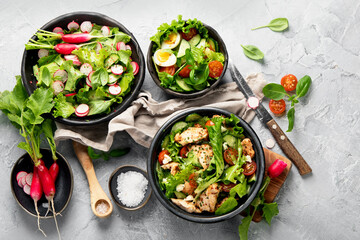 Freshly made salads on light gray background. Seasonal food concept.