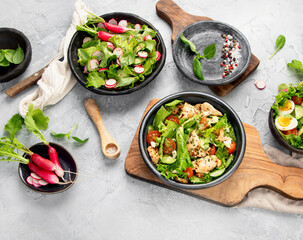 Freshly made salads on light gray background. Seasonal food concept.