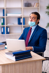 Fototapeta premium Young disabled employee during pandemic at workplace