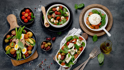 Obraz na płótnie Canvas Assorted salads on dark gray background. Seasonal food concept.