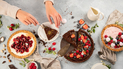 Different types of homemade tarts on light gray background.