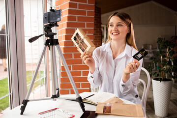 a woman hostess of an online store of homemade dry meat talks on a phone camera about her products....