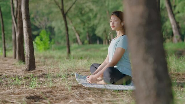 Asian cute girl She is doing yoga in the morning in the garden by the beach. and the sun shines, 4k resolution.