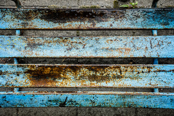 雨に濡れた古いベンチの座面はペンキが剥げて錆びている