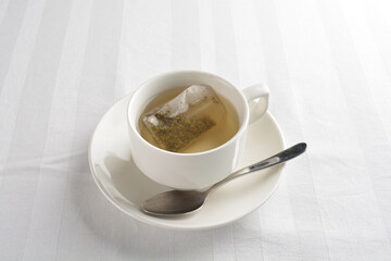 a cup of hot green tea leaf in bag on white background halal beverage menu
