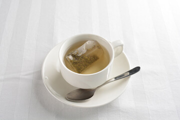a cup of hot green tea leaf in bag on white background halal beverage menu