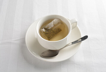a cup of hot green tea leaf in bag on white background halal beverage menu