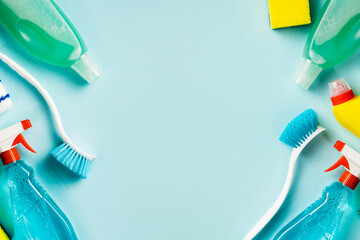 Frame from set various cleaning supplies on blue background with copy space, top view