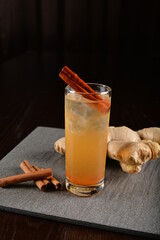 iced ginger soda mocktail with cinnamon kombucha in glass on bar counter dark night background cold halal drink menu