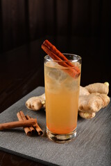 iced ginger soda mocktail with cinnamon kombucha in glass on bar counter dark night background cold halal drink menu