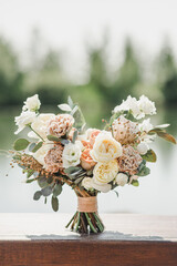 Bridal bouquet of white beige free-form flowers. Stands on a wooden support. Fine art. Light...