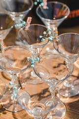 There are decorated empty martini glasses on the table, ready to be filled. The beginning of the holiday. Sunlight in the glass.