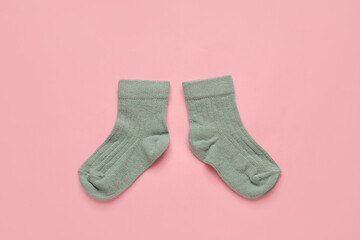 Baby socks on color background