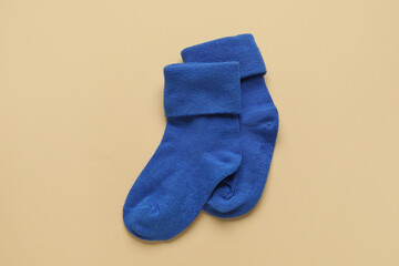 Baby socks on color background