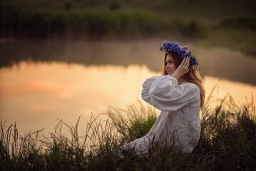 Photo of a girl in a wreath near the lake.