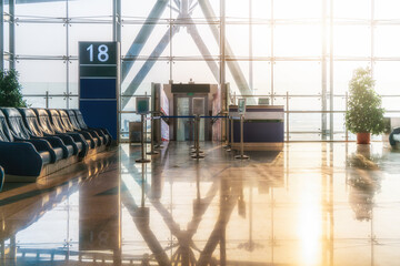 Floor-to-ceiling glass windows and lounge chairs in the airport ter