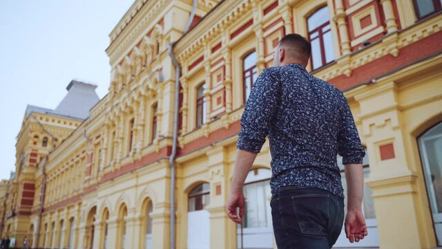 A man walks along a Russian historical building