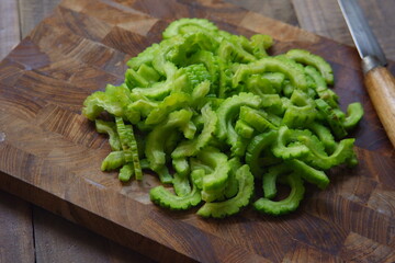 cuts of bitter melon in a wooden cutting board 