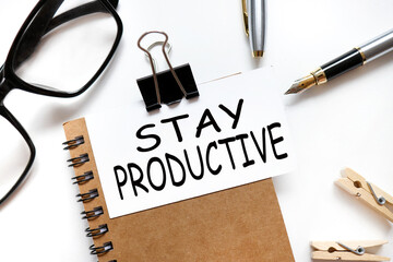 Stay Productive. the inscription on the business card is attached to the notebook.