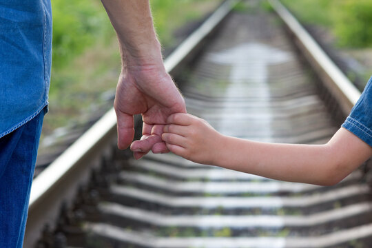  Parent Holds The Hand Of A Small Child