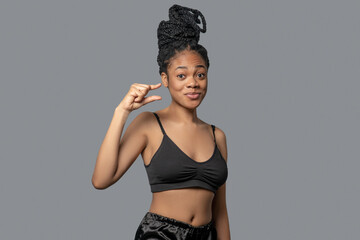 Woman with hair bun in black clothes gesticulating while expressing her emotions