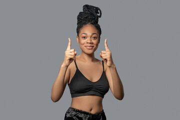 Woman with hair bun in black clothes gesticulating while expressing her emotions