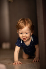 Little baby boy with a toy crawling on the floor at home. baby growth and development concept, pediatrics