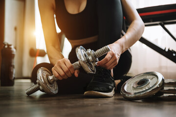 Determined woman losing weight at home and exercising with dumbbells. Sport and recreation concept. woman in sportswear .