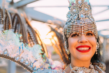 Fototapeta na wymiar Beautiful Brazilian woman wearing colorful Carnival costume and smiling during Carnaval street parade in city.