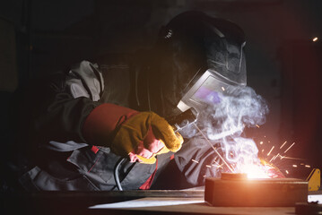 A welder is welding a metal close up.