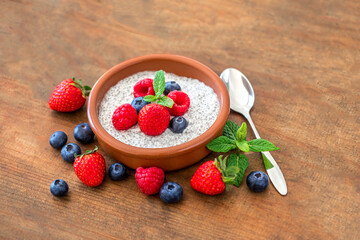 Chia seed pudding made with fruits and fresh  berries over wood background. Chia seeds Yogurt.