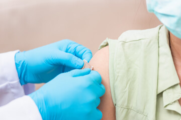 Vaccination, Doctor man after injection coronavirus vaccine to young woman shoulder he rubber...