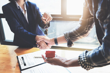Focus on the congratulatory handshake. The real estate agent agrees to buy the home and hand the...