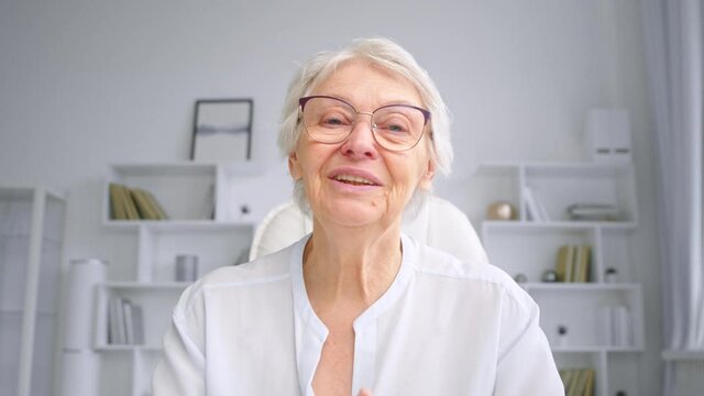 Senior businesswoman with short grey hair makes speech