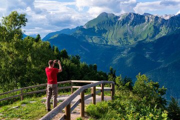 Fototapeta na wymiar Tourist taking photos of beautiful mountains