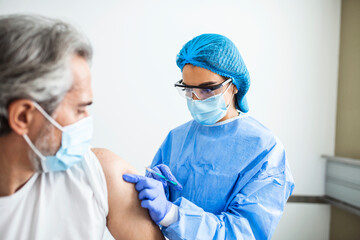 Fototapeta premium Close up doctor holding syringe and using cotton before make injection to patient in medical mask. Covid-19 or coronavirus vaccine