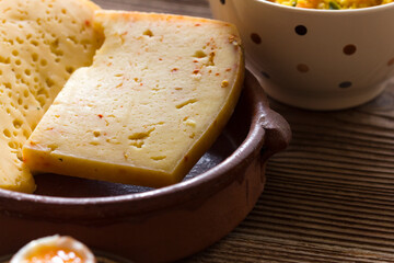 Boiled rice and vegetables with matured cheese on wooden background