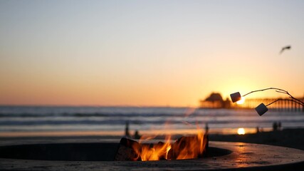 Campfire pit by Oceanside pier, California USA. Camp fire on ocean beach, bonfire flame in cement...