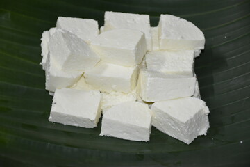 Cottage Cheese or Paneer or Panir, slice pieces of homemade fresh raw Paneer on Banana Leaf