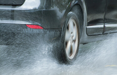 A Car Tire Splashing Through Water in Locarno, Switzerland.