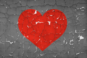 Red heart symbol on cracked dark gray paint texture