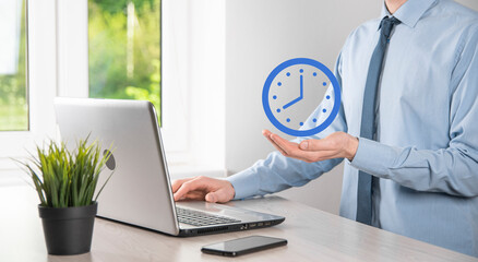 Businessman hand holds the icon of hours clock with arrow. Rapid execution of the work.Business...