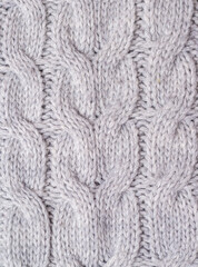 A fragment of a knitted plaid close-up of gray color. Vertical