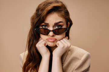 portrait of a beautiful woman with glasses sad look and hands near the face hairstyle