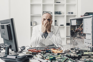 Frustrated exhausted technician repairing a computer