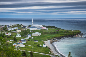 Fototapeta premium View on the small village of St Maurice de l'Echouerie with its small white church, beach and houses in Gaspesie (Quebec, Canada)