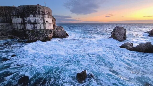 Rough sea with waves and rocks at sunset in dubrovnik