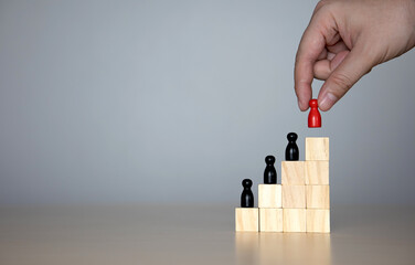 wooden doll in a hierarchy of wooden blocks. The concept of raising the level of individuals in the...