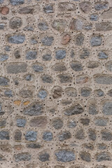 Architecture textures, detailed and rustic of irregular paired masonry granite mix with small holes, traditional spanish granite wall