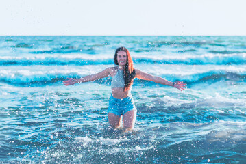 Young woman playing in the sea.woman enjoying in sea water .Cheerful young woman having fun on the summer beach.